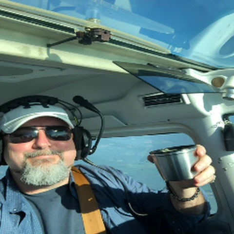 Jim Coffey II, founder of Searchooli, seated in the cockpit of an aircraft.